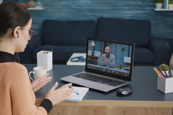 Young woman meeting with teacher on remote video call, talking about online class education and lesson. Student chatting with man on videoconference webinar, using laptop with webcam.